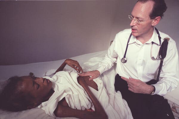 Dr. Paul Farmer speaking with an H.I.V. patient, Altagrace Cenatus, at a Partners in Health hospital in Haiti in 2003. He worked to provide quality health care to some of the poorest people in the world.
